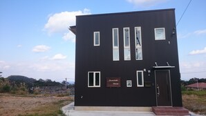 Un bâtiment moderne de couleur noire, doté de nombreuses fenêtres et d’une enseigne indiquant « Maison du chocolat ».
