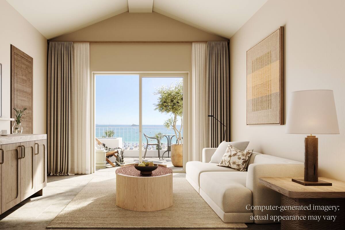 A modern living room with a large window, a flat-screen TV, a coffee machine, a sofa, and a lamp.