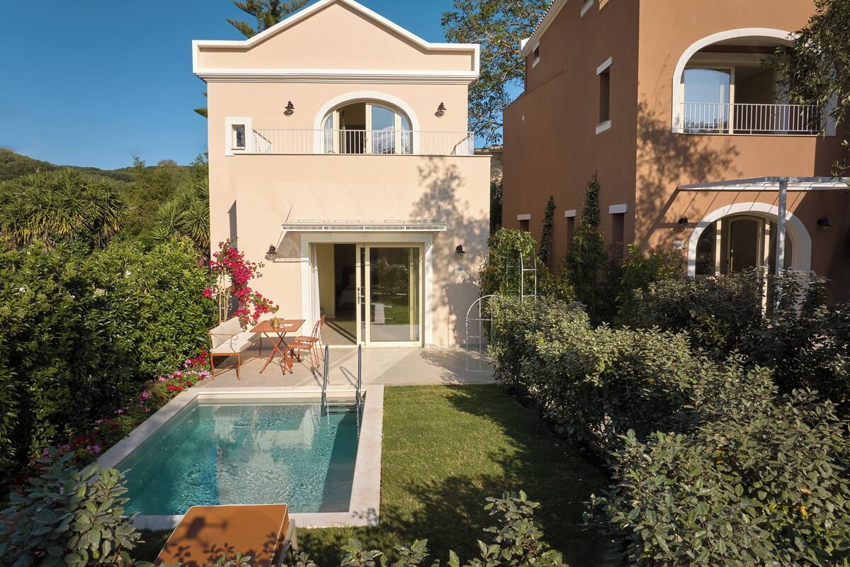 A two-story house with a swimming pool, a covered patio, and a well-maintained garden.