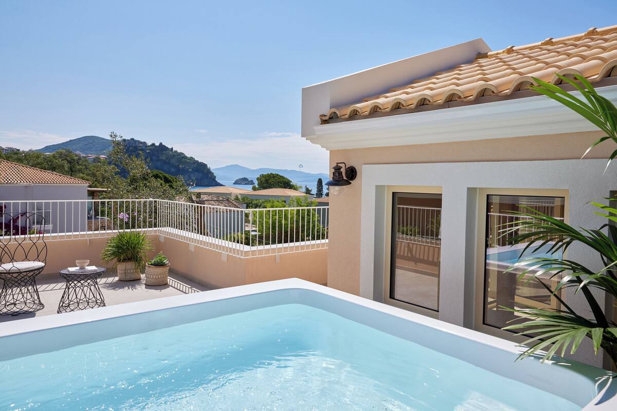 A rooftop pool with a clear view of the surrounding landscape, including hills and a distant island.