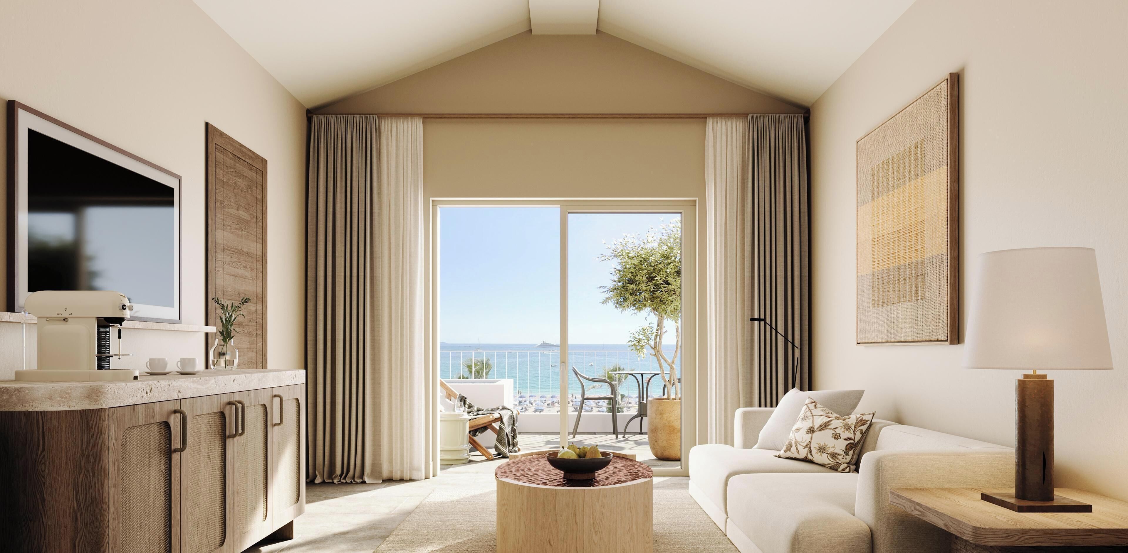 A modern living room with a large window, a flat-screen TV, a sofa, a coffee table, and a view of the ocean.
