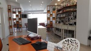 A modern office space with a desktop computer, a calendar, and a coffee machine. - Hostal Gran Vía (Pinto)