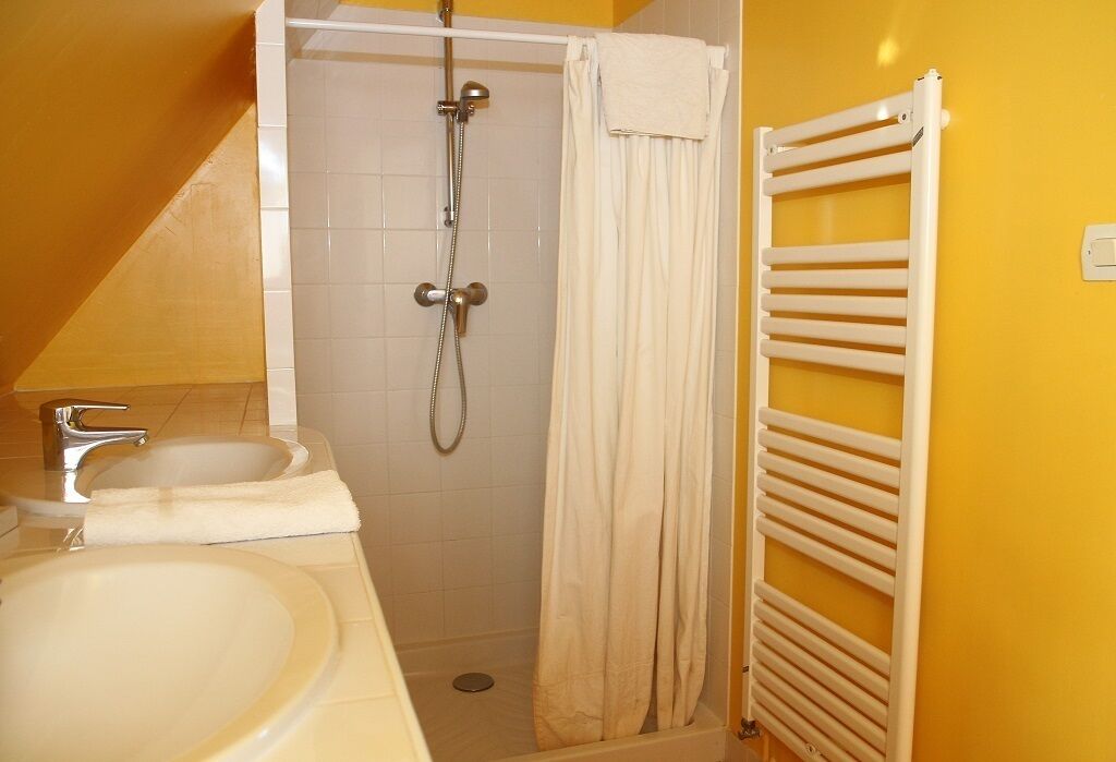 Ein Badezimmer mit Dusche, Waschbecken und Handtuchhalter.