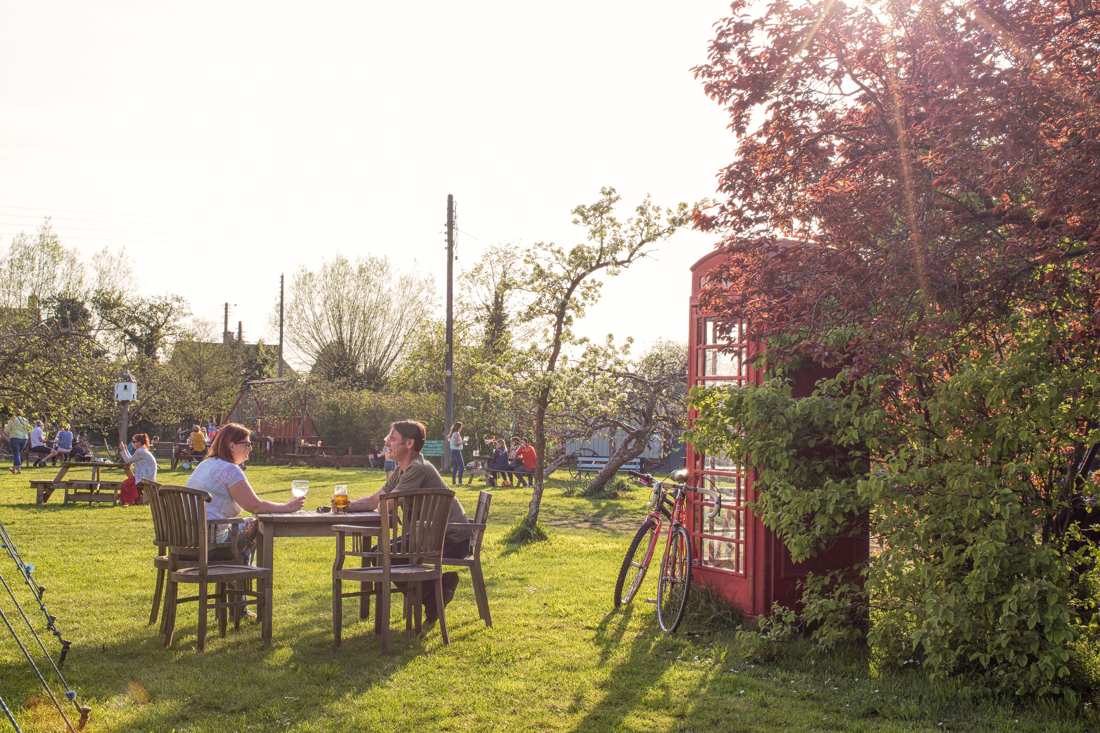 Un parc avec des tables de pique-nique et une structure rouge.