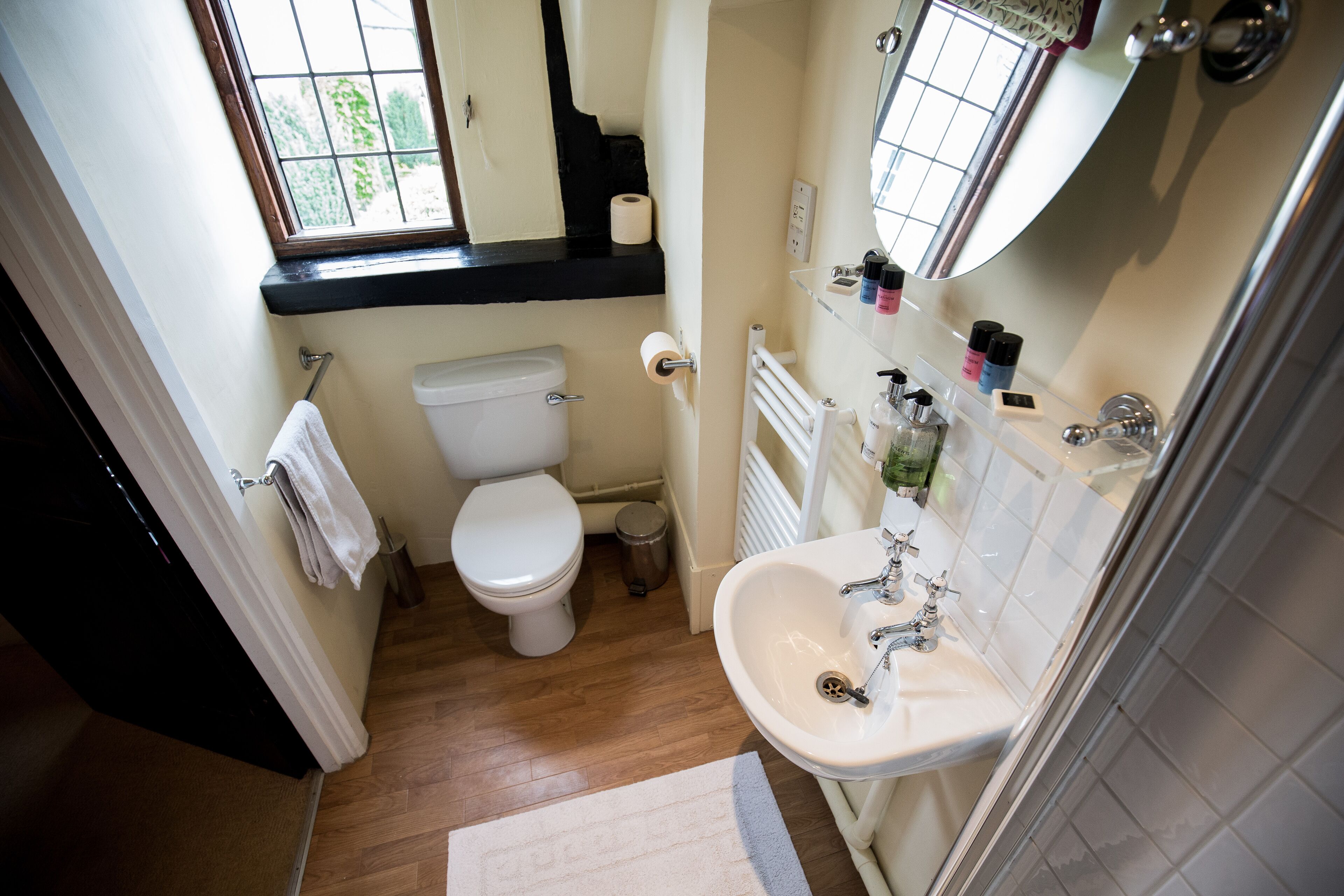 A compact bathroom with a toilet, sink, and window.