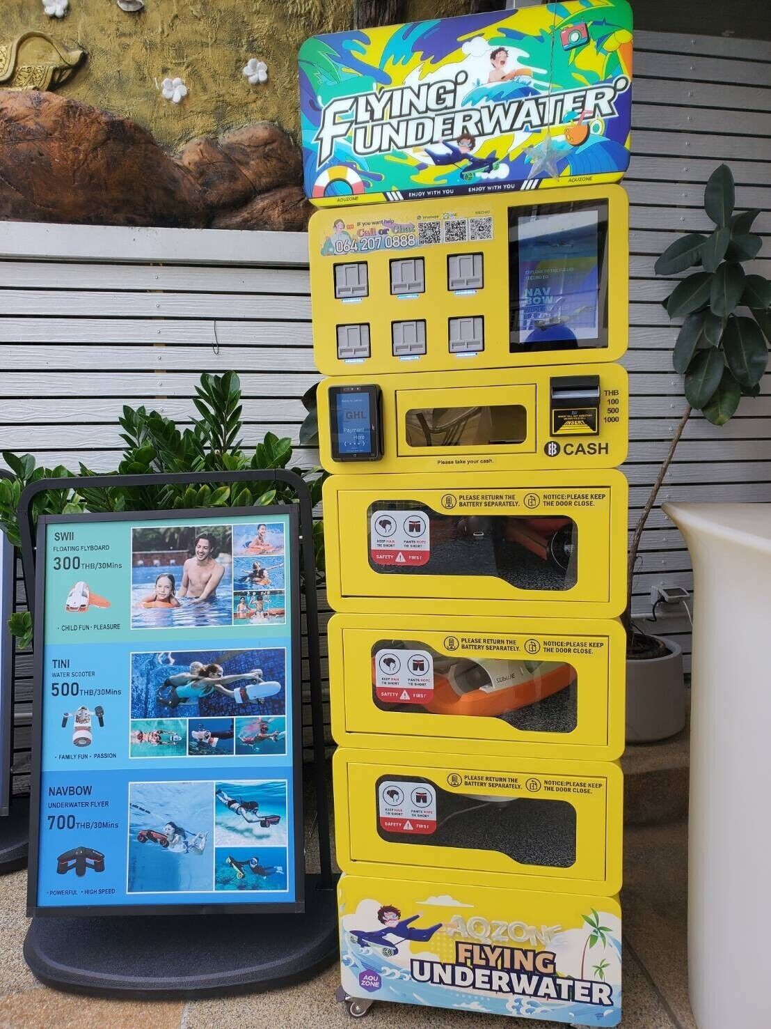 Un espace de jeux aquatiques agrémenté d'un panneau indiquant « Vol sous-marin », avec un scooter aquatique, une planche à hydroglissement flottante et un appareil de vol sous-marin NavBow.