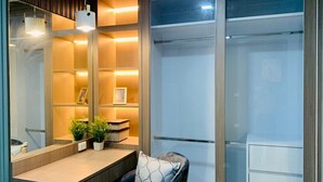 Ein moderner Arbeitsraum mit Schreibtisch, Stuhl, Regalen und einem großen Fenster.
