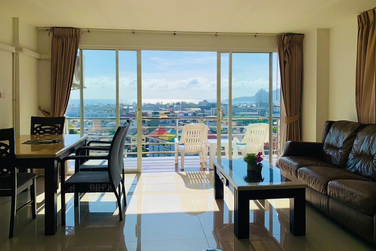 A spacious living room with a balcony, a dining area, and a sofa.