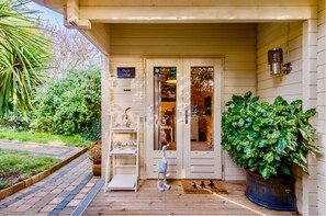 A wooden porch with a white door labeled "Duck Lodge." - Duck Lodge B&B (Brighton)