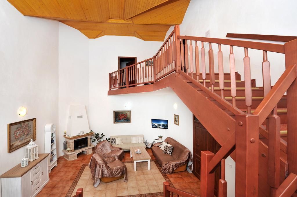Un salon avec un escalier en bois, un canapé, une table basse et une cheminée.