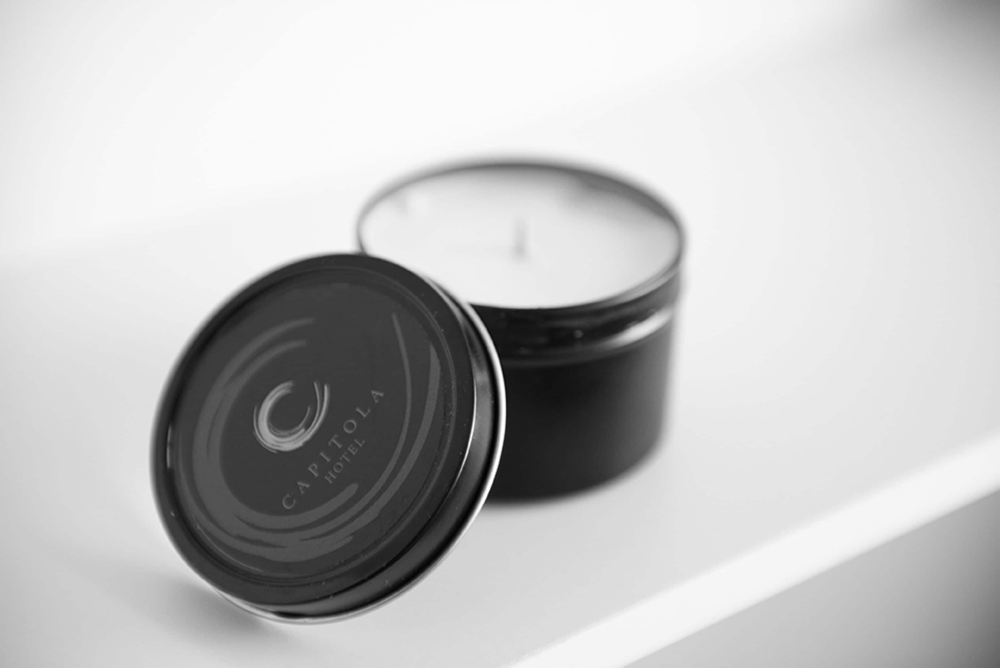 A black candle with the text "CAPITOL HOTEL" on its lid.