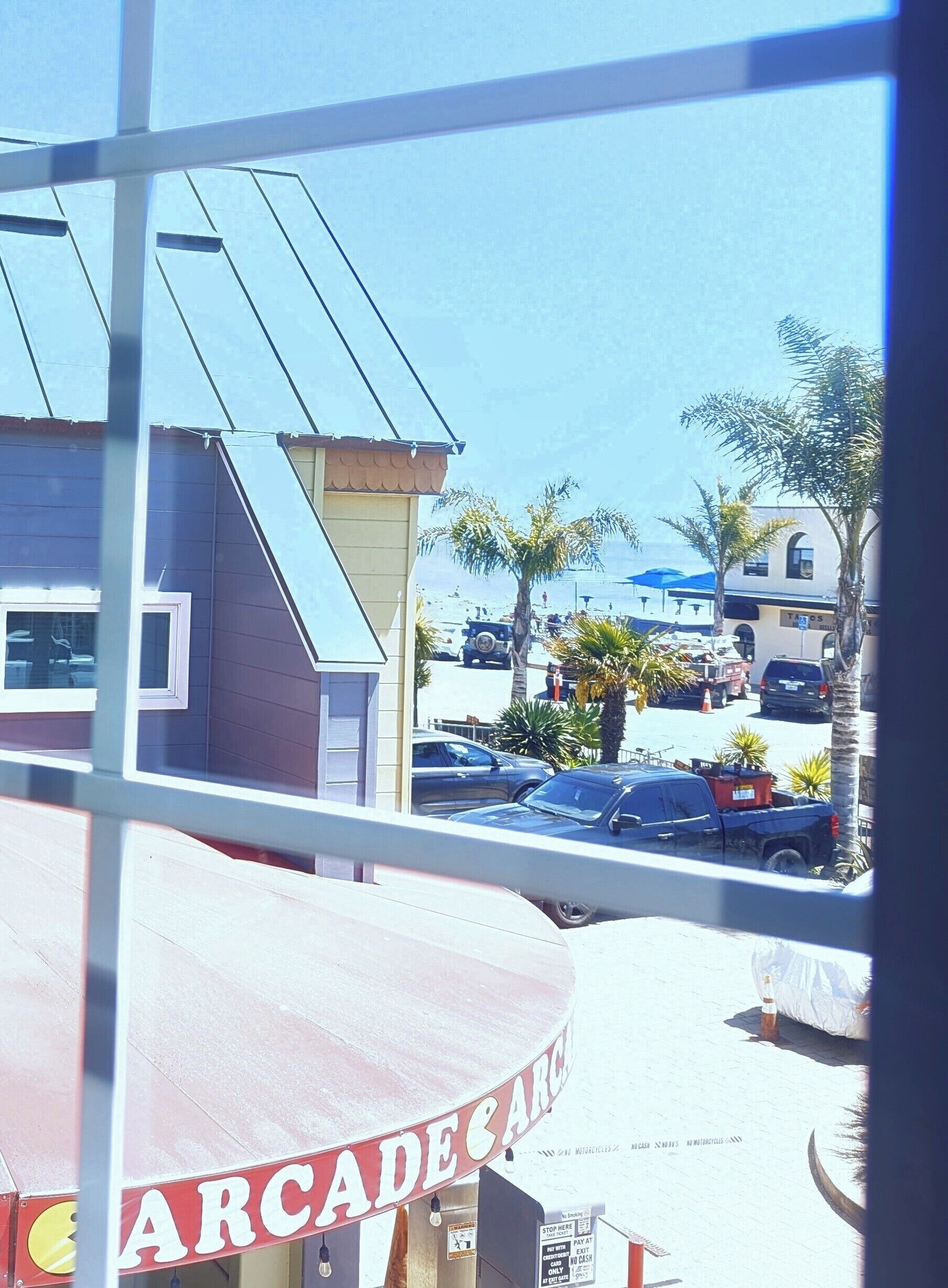 A view of a parking lot with cars and a building in the background.