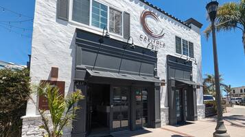 Stucco-clad Capitol Hotel features a charming entrance with a black awning and two doors.