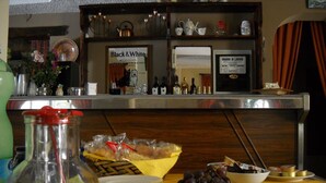 A bar area with a variety of food items, a bottle of orange juice, and a sign for Black & White Scotch whisky.