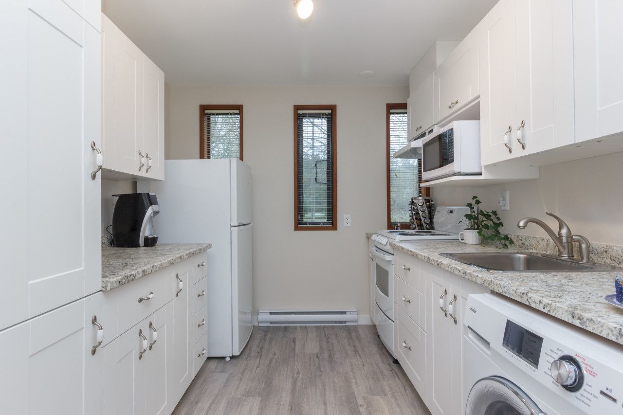A modern kitchen with white cabinets, a built-in microwave, a stove, and a dishwasher.