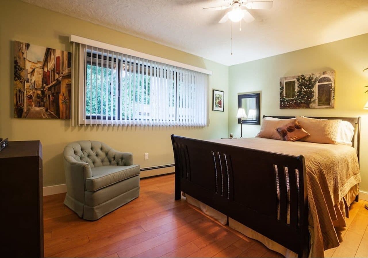 A bedroom with a bed, a chair, and a desk.
