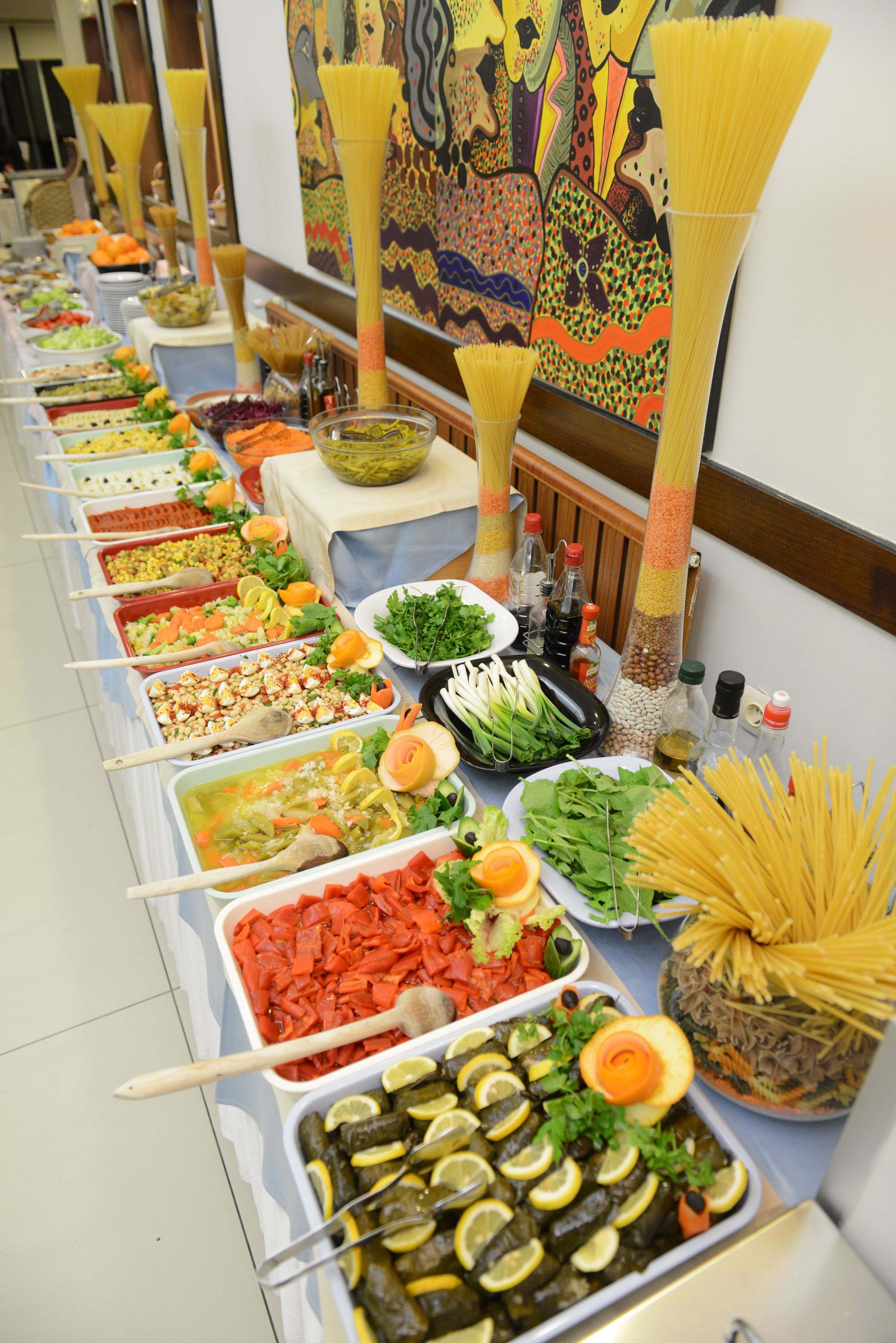 A buffet table with various food items and serving utensils.