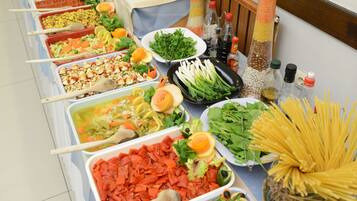 A buffet table with various food items and serving utensils.