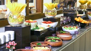 A buffet with various food items and a decorative horse statue. - Çanak Hotel (Çanakkale)