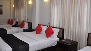 A hotel room with two beds, each with white bedding and red pillows, a nightstand with a lamp, and a large mirror reflecting the room. - Laa Adams (Hatton)