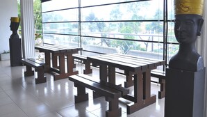 A room with a large window, wooden benches, and two bust sculptures. - Laa Adams (Hatton)