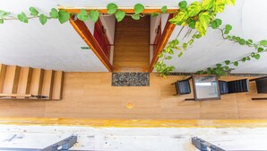 L’entrée d’un hôtel avec un escalier en bois, un comptoir d’accueil et une plante en pot.
