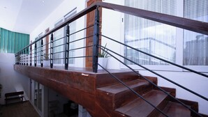 Un escalier en bois avec des rampes en métal menant à l’étage supérieur.
