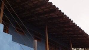 Un bâtiment à la façade bleue, doté d’un escalier en bois et d’un toit recouvert de tuiles.