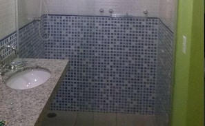 A bathroom with a sink, mirror, and tiled walls.