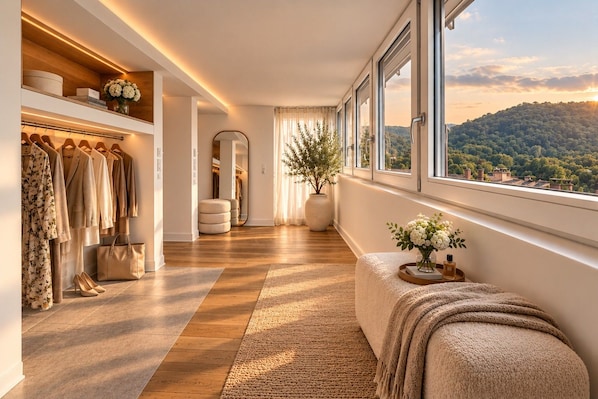 A modern interior with a wooden floor, a bench, a mirror, a plant, and a view of the outdoors.