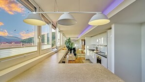 A modern kitchen with a large island, pendant lighting, and a view of the outdoors. - Boutique Suites and Residences Heidelberg – Alte Zigarrenmanufaktur (Heidelberg)