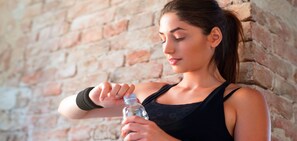 A person holding a water bottle against a brick wall. - Boutique Suites and Residences Heidelberg – Alte Zigarrenmanufaktur (Heidelberg)