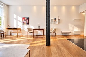 Ein modernes Wohnzimmer mit Holzboden, einem Esstisch, einer Couch und einem Couchtisch.