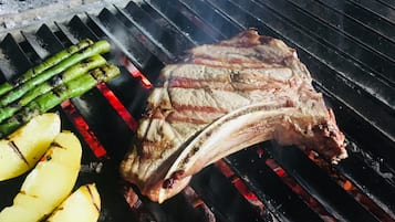 A steak and asparagus grilling on a barbecue.