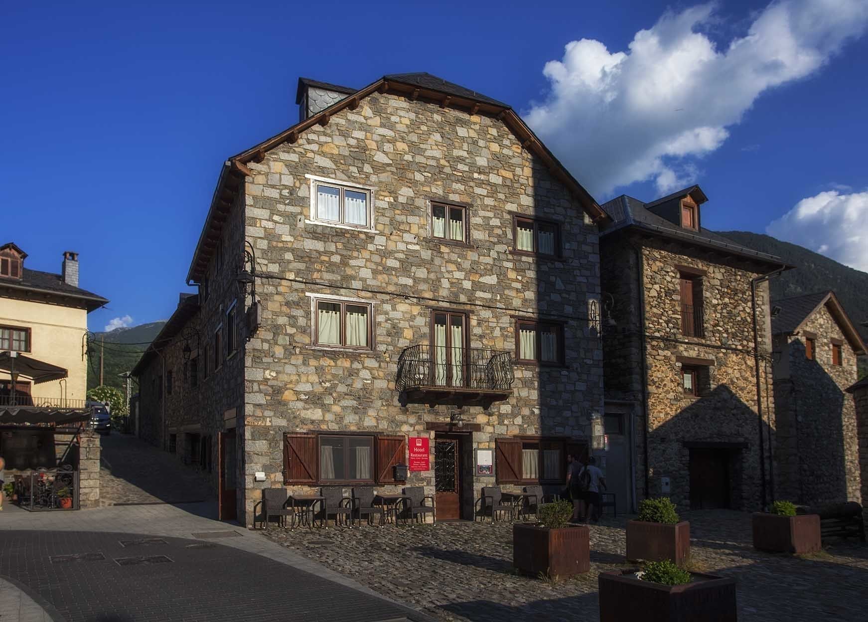 Un bâtiment en pierre avec une enseigne indiquant qu’il s’agit d’un hôtel.