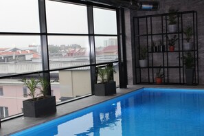 Una piscina techada, sillones reclinables de piscina