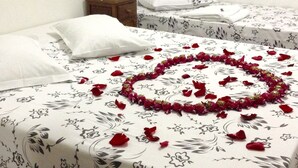 A hotel room with two beds, each with a floral bedspread and white pillows. - Hotel Pousada Alvorada (Brotas)