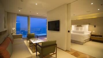 Une chambre d’hôtel moderne dotée d’un balcon, d’un canapé, d’une table à manger et d’un lit.
