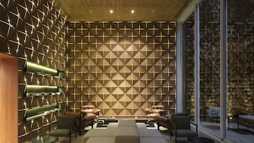 Relax in this stylish space with a geometric patterned wall, comfortable seating, and a large window offering a view.