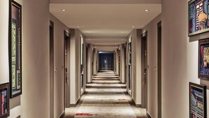 A long, narrow hotel corridor with doors on both sides, a patterned carpet, and framed artwork on the walls. - Mercure Kuala Lumpur Shaw Parade (Kuala Lumpur)
