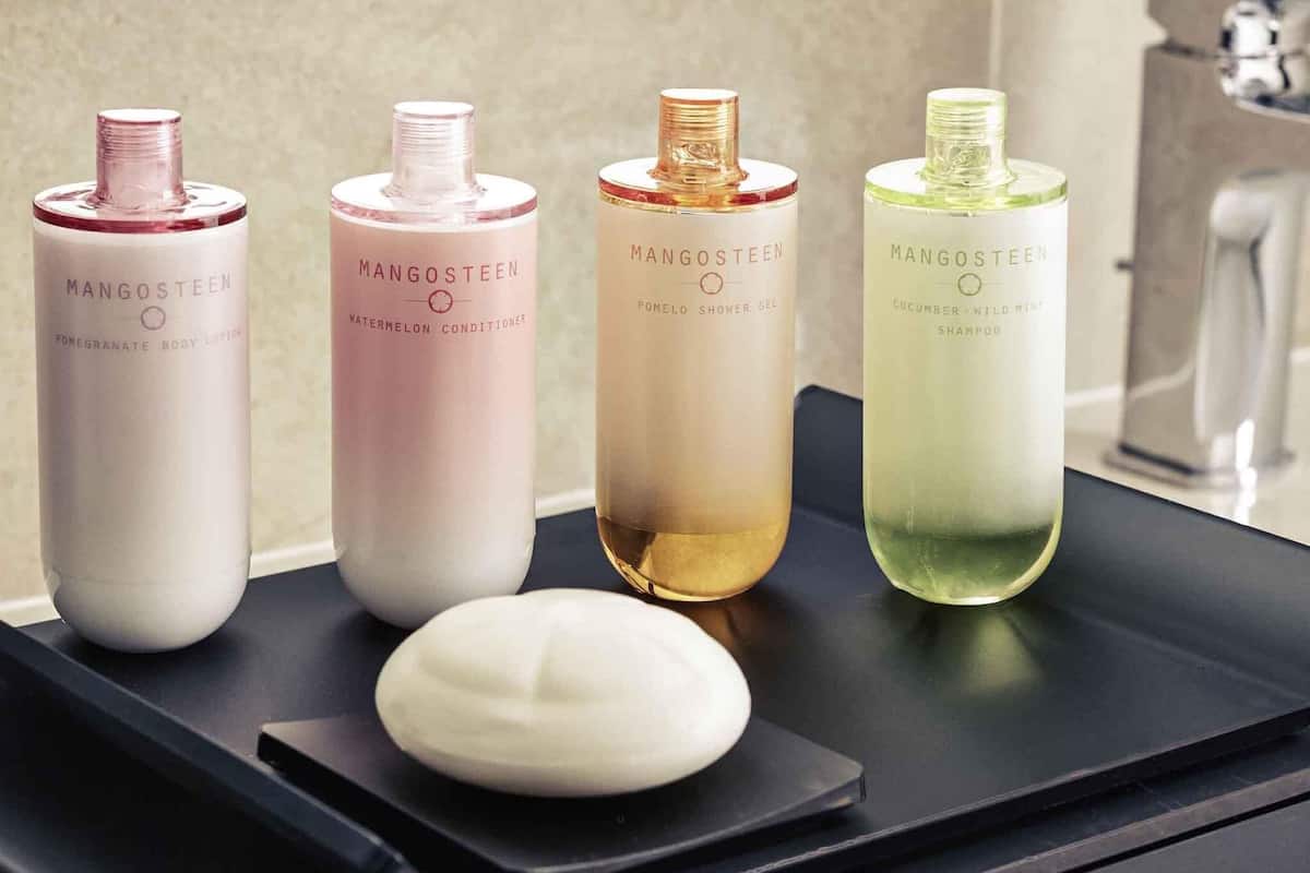 Four bottles of Mangosteen body care products on a black tray.