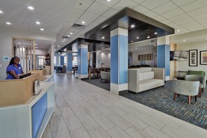 A hotel lobby with a reception desk, seating area, and a conference room. - Holiday Inn Express & Suites Houston East - Beltway 8 by IHG (Houston)