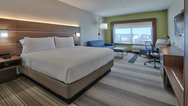A modern hotel room with a large bed, a desk, a chair, and a TV. - Holiday Inn Express & Suites Houston East - Beltway 8 by IHG (Houston)