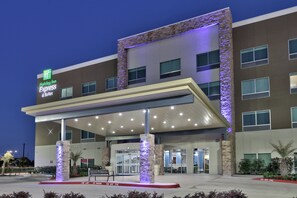 A Holiday Inn Express & Suites hotel with a covered entrance, stone pillars, and a fire lane. - Holiday Inn Express & Suites Houston East - Beltway 8 by IHG (Houston)