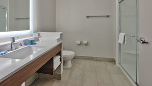 A modern bathroom with a large mirror, a sink, a toilet, and a glass shower enclosure. - Holiday Inn Express & Suites Houston East - Beltway 8 by IHG (Houston)