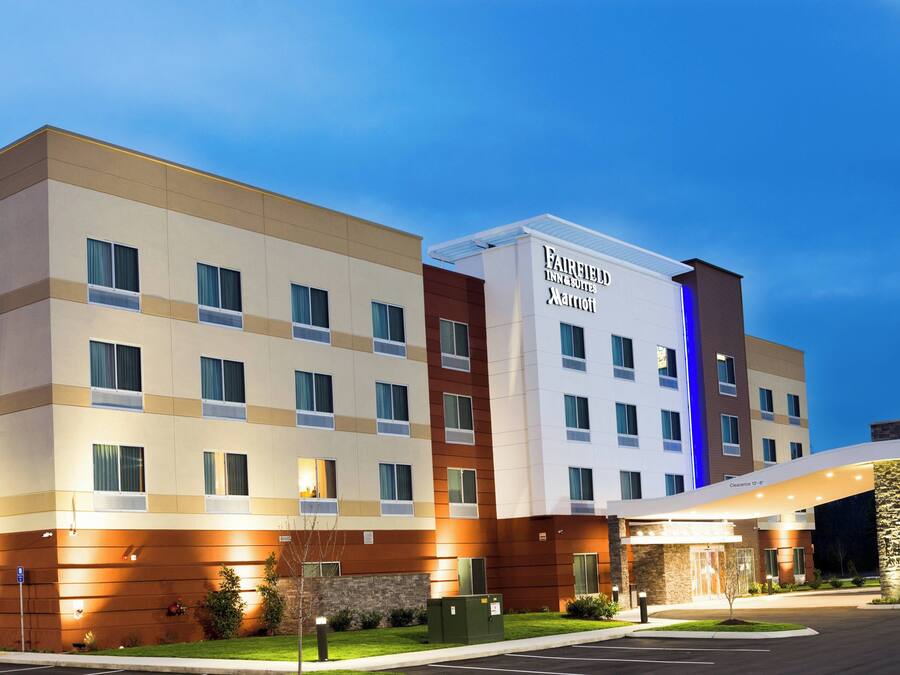 Ein Hotel Fairfield Inn & Suites by Marriott mit modernem Design, mehreren Etagen und einem gut beleuchteten Eingang.