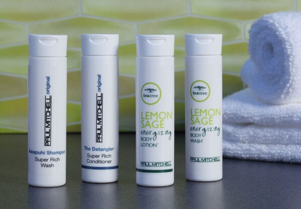 Four bottles of Paul Mitchell hair care products on a bathroom counter.
