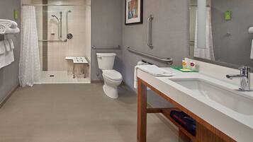 A modern bathroom with a shower, toilet, and sink.