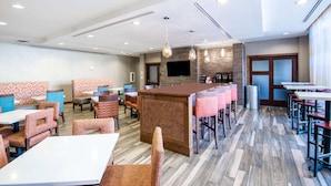 A modern restaurant with booths, high tables, and a bar area. - La Quinta Inn & Suites by Wyndham Durango (Durango)