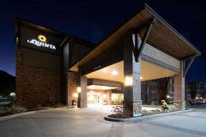A hotel entrance with a prominent sign, a covered walkway, and a landscaped area with plants. - La Quinta Inn & Suites by Wyndham Durango (Durango)
